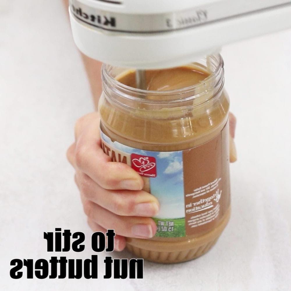 Handmixer rührt Erdnussbutter. Text: Nussbutter rühren.