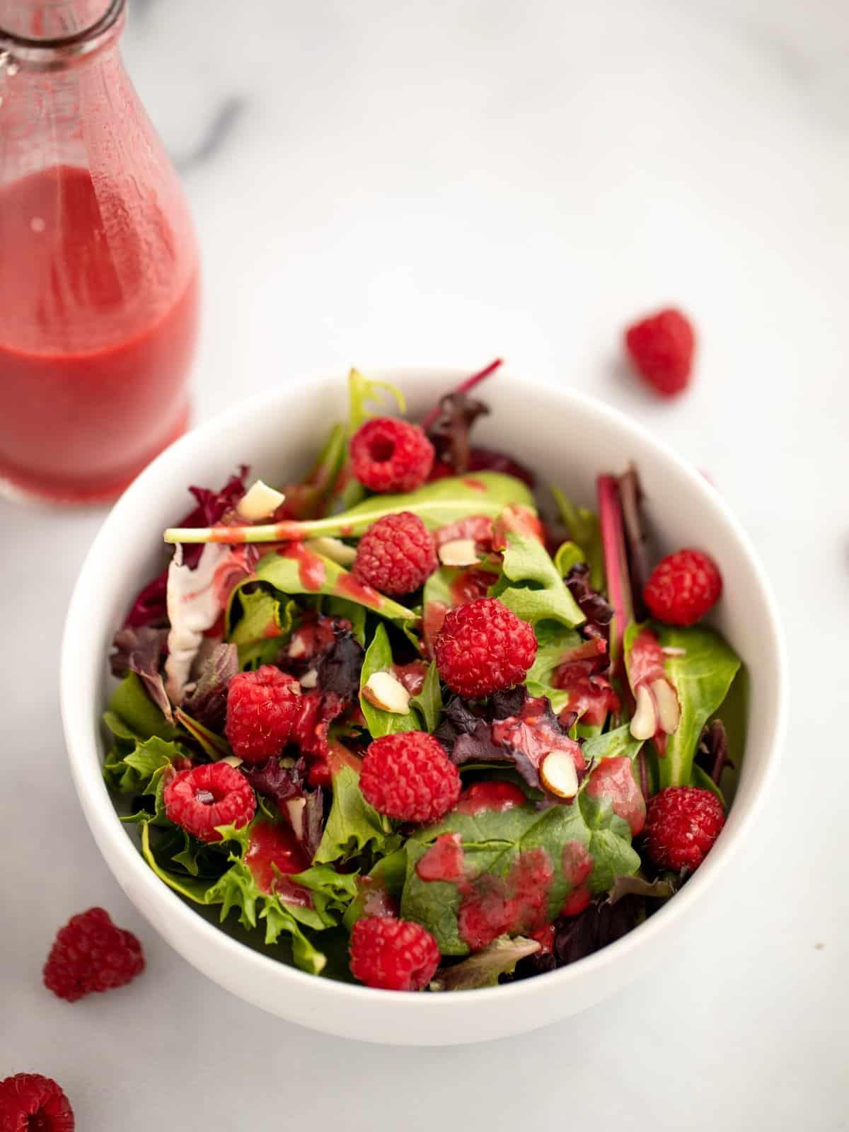 Gemischte Blattsalate mit Himbeeren und frischer Himbeer-Vinaigrette.