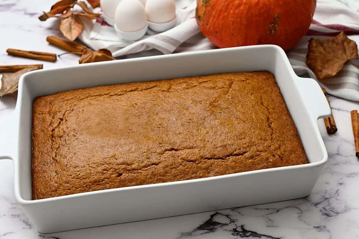 Selbstgemachter Kürbiskuchen Gebackener Kürbisgewürzkuchen in einer weißen 9x13 Kuchenform.