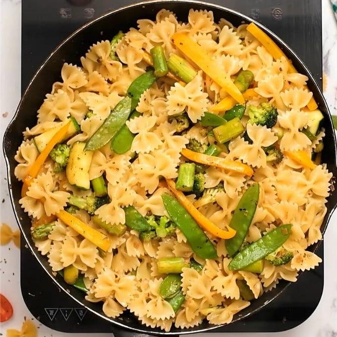 Pasta mit angebratenem Gemüse in einer Pfanne.