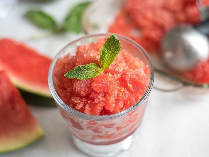 Hausgemachte Wassermelonen Granita Wassermelonen Granita in einer Glasschale, garniert mit Minze.