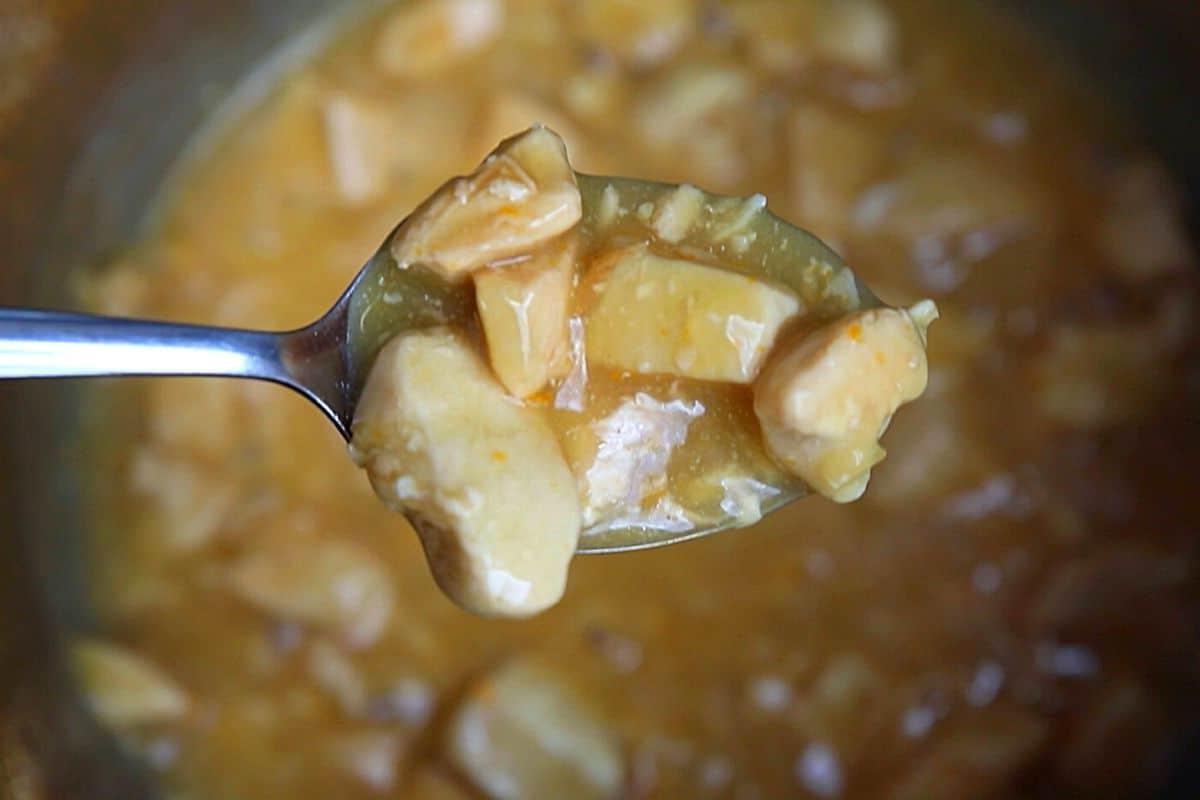 Löffel, der Orangen-Hähnchen aus dem Instant Pot schöpft.