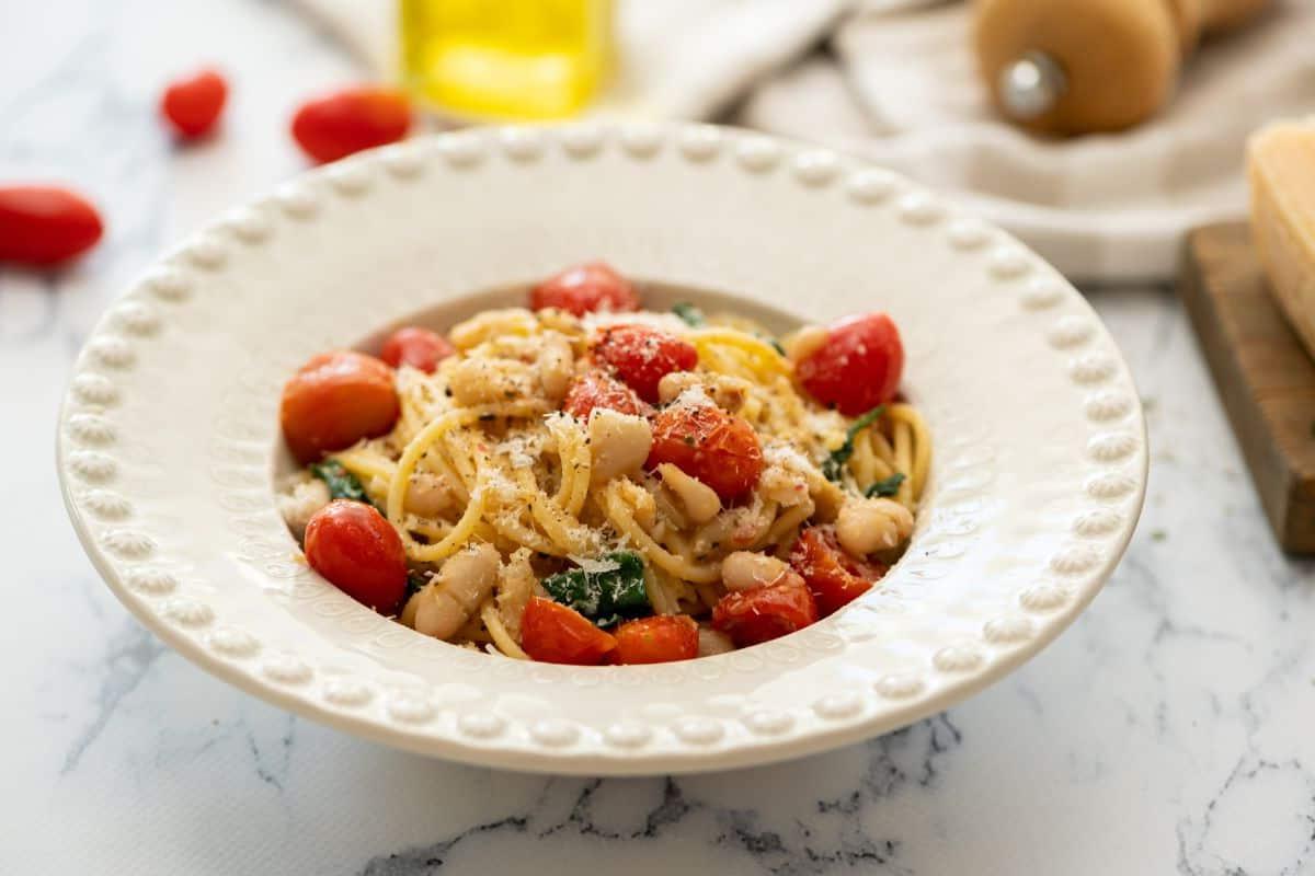 Schüssel mit weißer Bohnen Pasta, angerichtet in einer weißen Schüssel, mit Parmesan bestreut.
