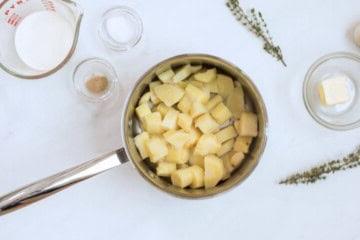 Pastinaken und geschälter Knoblauch im Topf nach dem Köcheln, bis sie gabelzart sind.