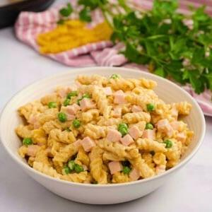 Schüssel mit Instant Pot Schinken-Käse-Pasta mit Instant Pot im Hintergrund.