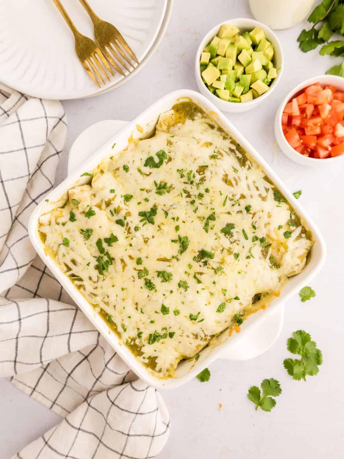 Gebackene Hähnchen-Salsa-Verde-Enchiladas, garniert mit gehacktem Koriander.