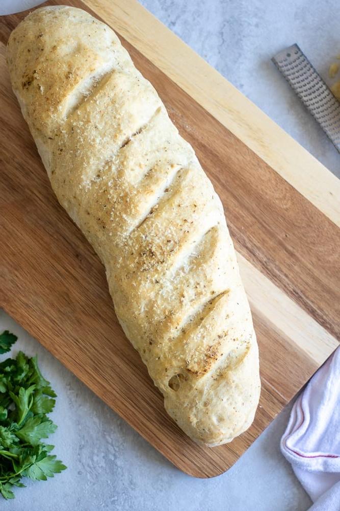 Rezept für italienisches Brot Gebackenes italienisches Brot auf einem Schneidebrett.