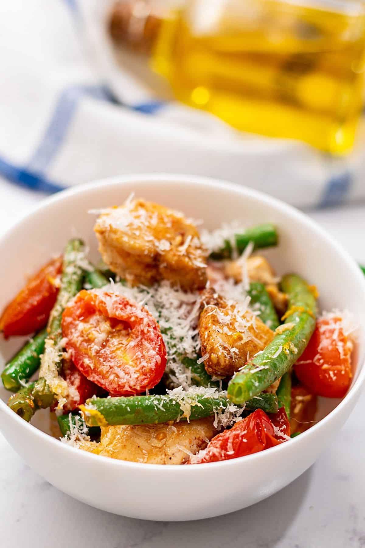 Schüssel mit Hähnchen und grünen Bohnen mit Tomaten.