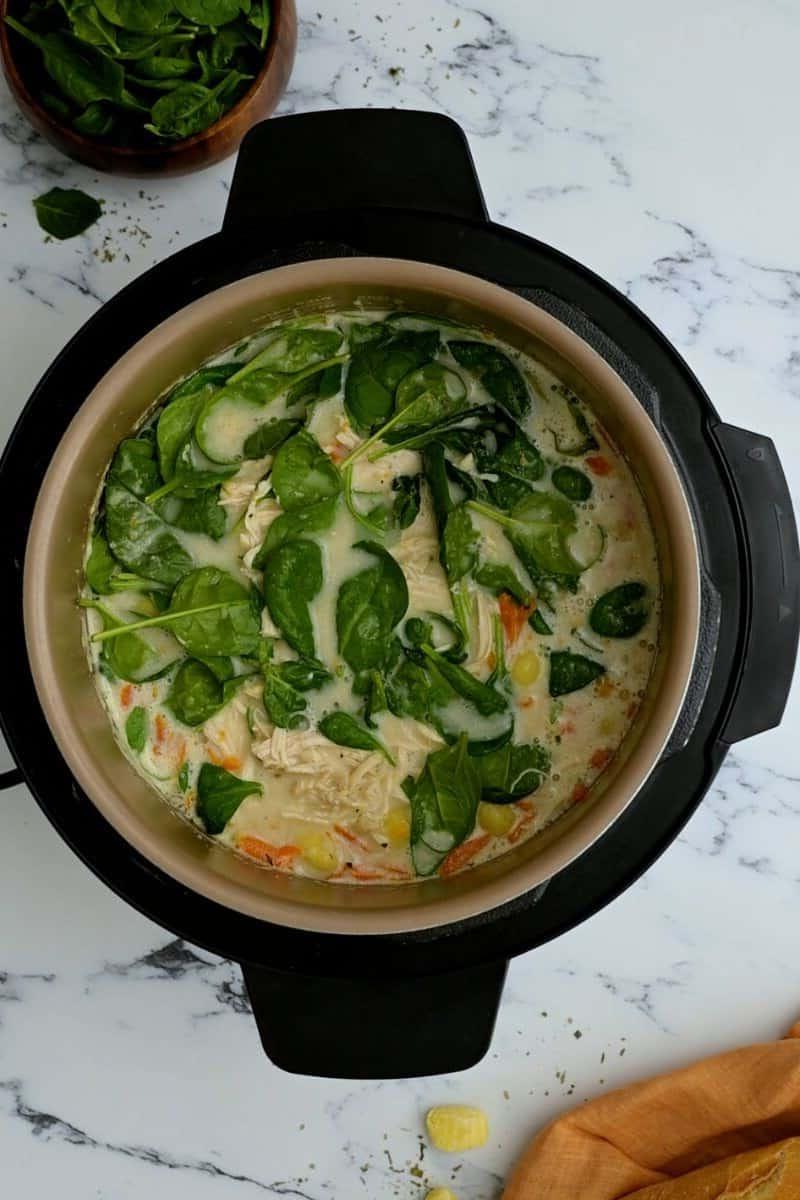 Instant Pot gefüllt mit cremiger Hähnchen-Gnocchi-Suppe, garniert mit frischem Spinat.