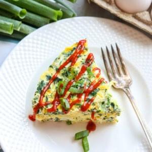 Scheibe Spinat-Eier-Frittata auf weißem Teller