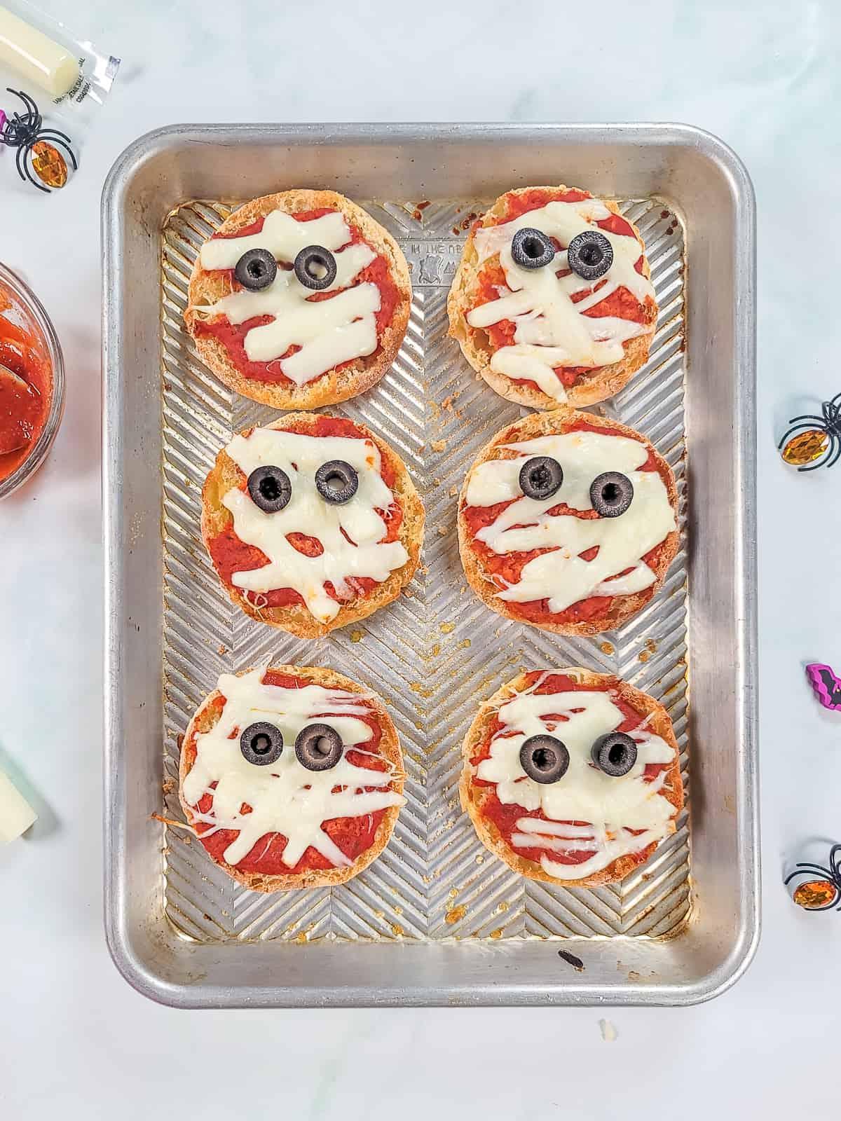 Mumien-Pizzas auf einem Backblech.