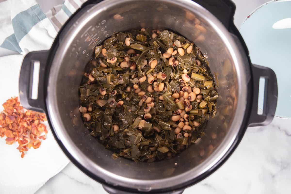 Instant Pot Augenbohnen Gekochte Augenbohnen und Blattkohl im Innentopf.