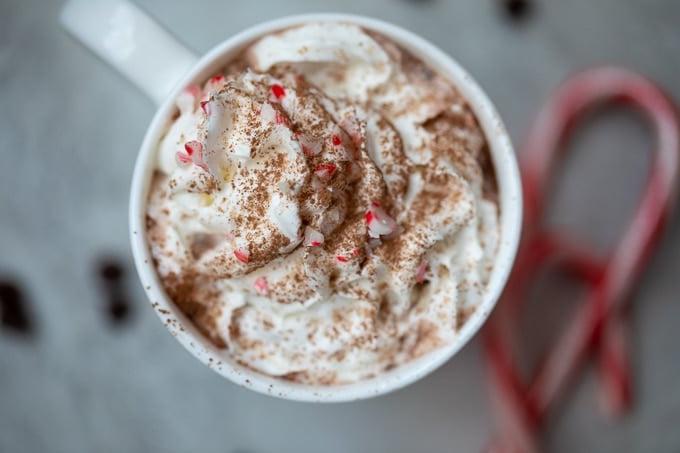 Heisse Schokolade Rezept mit Schokolade Tasse heißer Schokolade neben Zuckerstangen.