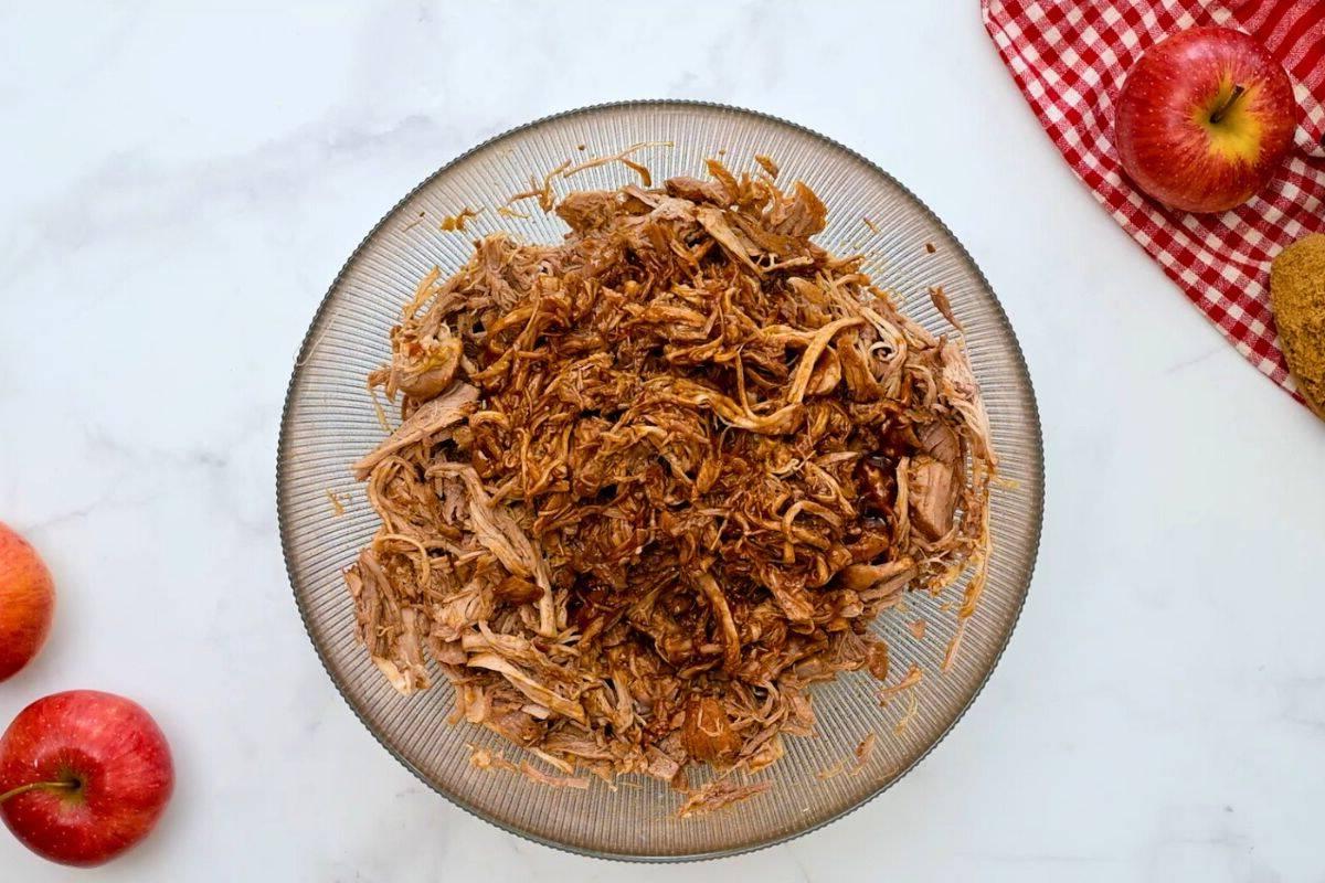 Pulled Pork mit etwas Barbecue-Soße in einer großen Rührschüssel.