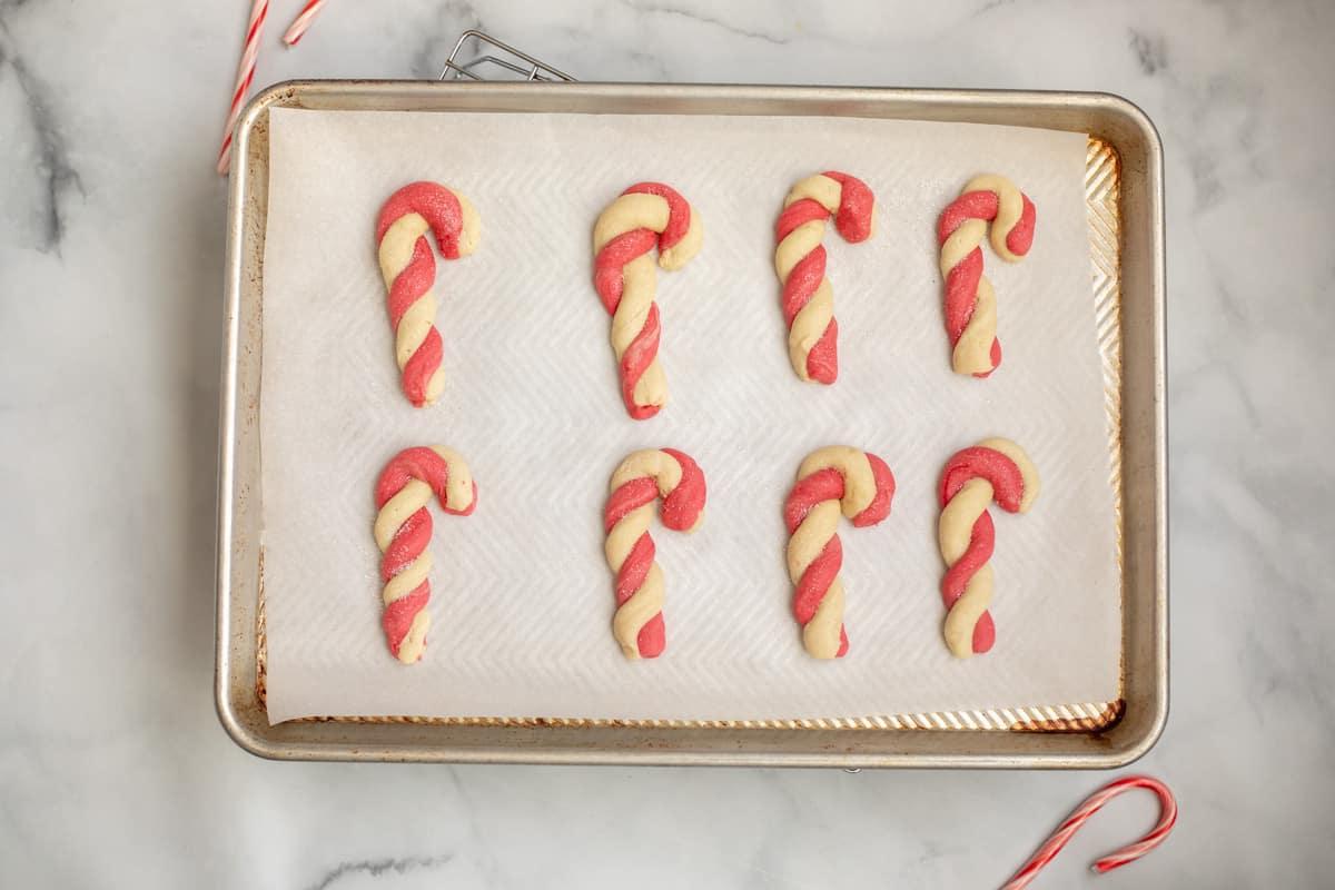 Gebackene Zuckerstangen-Plätzchen, bestäubt mit Glitzerzucker.