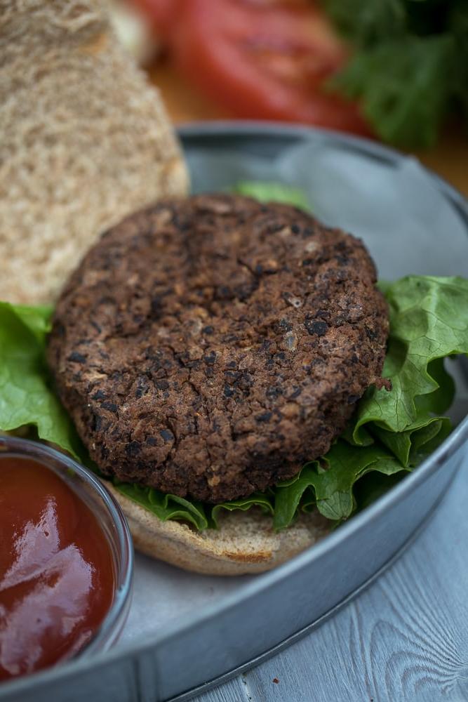 Schwarzer Bohnen-Patty auf Salat auf Vollkornbrötchen.