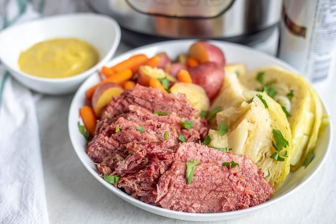 Corned Beef, Kohl, Kartoffeln und Karotten auf einer weißen Servierplatte.