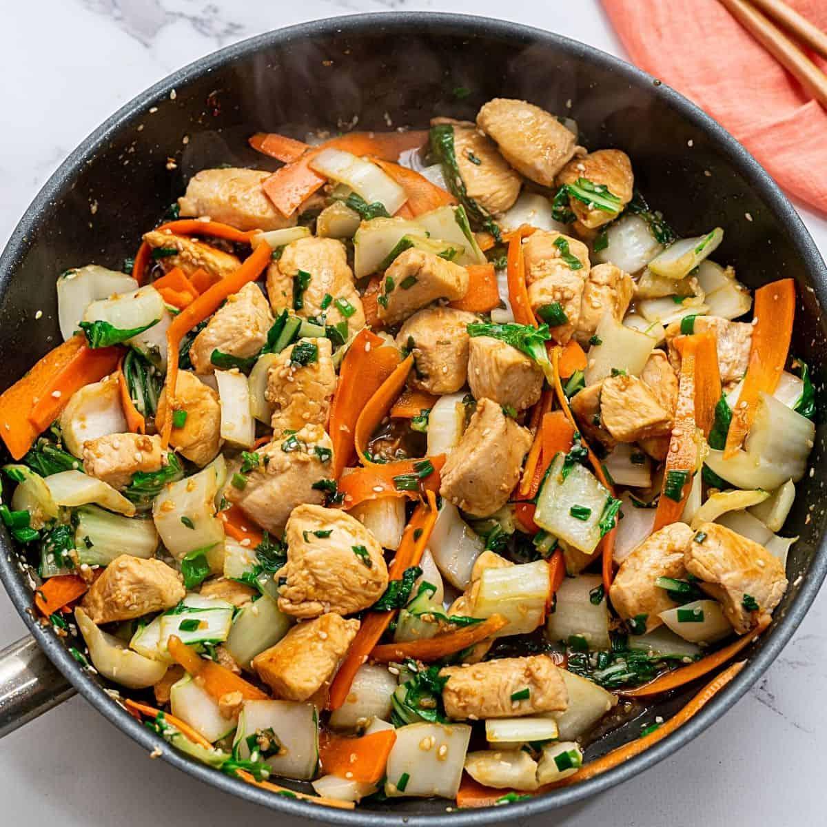 Hähnchen- und Bok Choy-Stir-Fry in einer antihaftbeschichteten Pfanne.