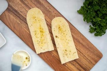 Gewürztes Olivenöl auf geschnittenem Baguette verstrichen.