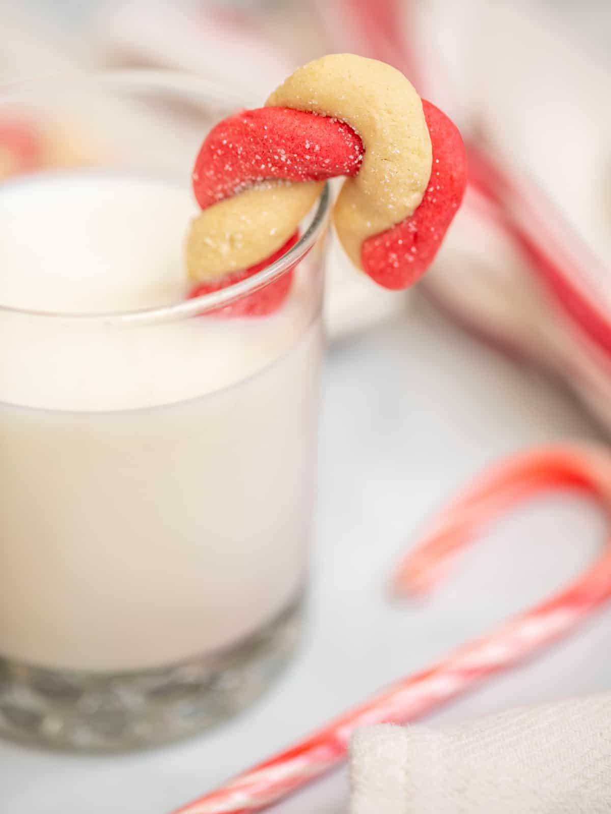 Zuckerstangen-Plätzchen taucht in ein Glas Milch.