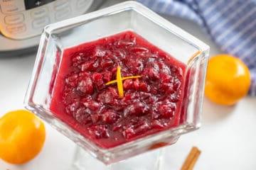 Preiselbeersauce mit Orangenschale garniert neben dem Innenbehälter.