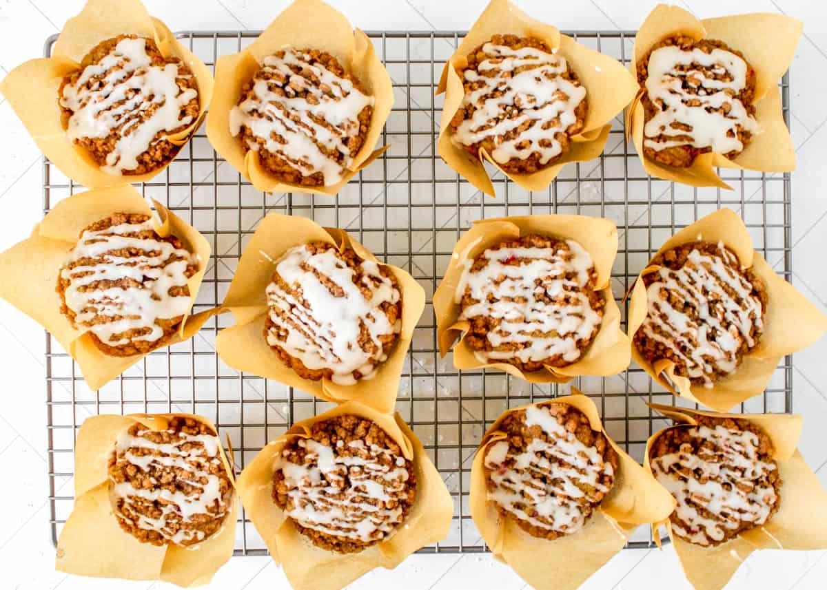Cranberry-Orangen-Muffins mit Glasur auf einem Kühlgitter.
