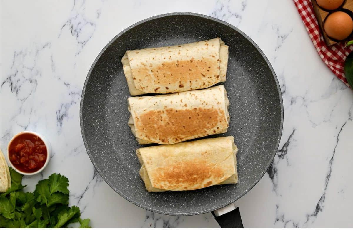Getoastete Frühstücks-Burritos in einer trockenen Pfanne.