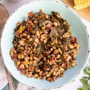 **Schwarzaugenbohnen mit Blattgemüse aus dem Schnellkochtopf** 2 Instant Pot Augenbohnen mit Blattkohl in einer blauen Servierschale.