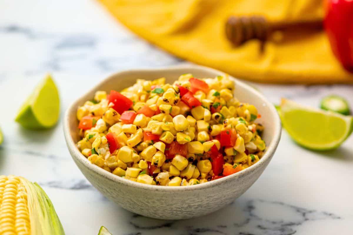 Schale mit gegrillter Maissalsa mit roter Paprika und Honig-Limettendressing.
