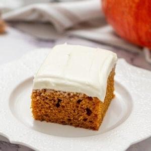 Kürbiskuchen 2 Ein Stück Kürbiskuchen mit Frischkäse-Frosting auf einem weißen Teller.