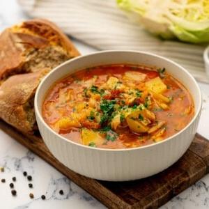 Schnellkochtopf-Kohlsuppe 2 Instant Pot Kohlsuppe in einer Schüssel neben herzhaften Brötchen.