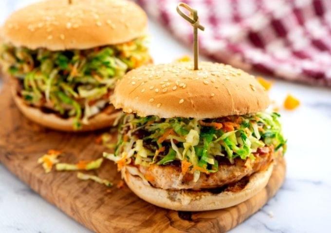 BBQ Chicken Burgers on Cutting Board on bun with coleslaw.