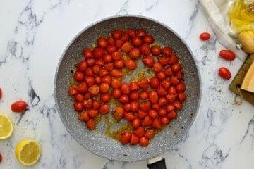 Halbierte Datteltomaten in der Pfanne mit Gewürzen angebraten.