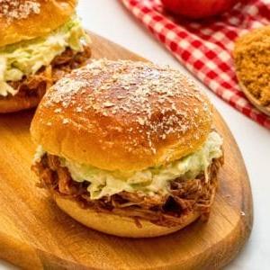 Instant Pot Pulled Pork in Brötchen serviert, garniert mit hausgemachtem cremigem Krautsalat.
