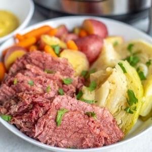 Corned Beef und Kohl auf einer weißen Platte mit Kartoffeln und Karotten.
