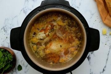 Innerer Topf mit pochiertem Hähnchen in Brühe für die Gnocchi Suppe.
