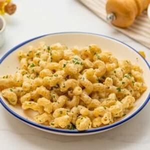 Cavatappi-Nudeln in cremiger Parmesan-Soße, garniert mit frischer Petersilie, Nahaufnahme.