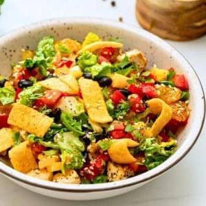 Karibischer Salat mit gewürfeltem Hähnchen, Orangen-Vinaigrette, schwarzen Bohnen, Mango, Ananas, roter Paprika und Mandarinen.