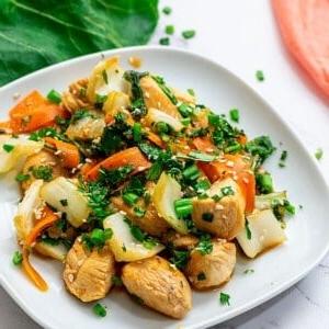 Teller mit Hähnchen- und Bok Choy-Stir-Fry, garniert mit Koriander.