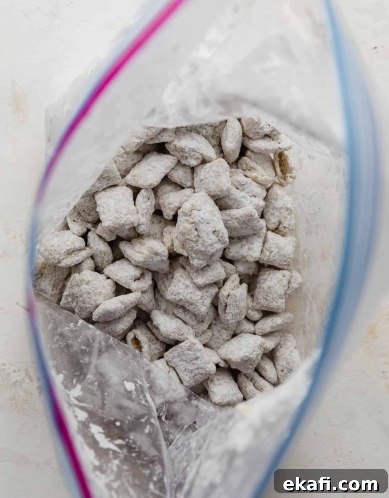 Φωτογραφία από πάνω μιας ανοιχτής σακούλας Ziplock γεμάτη με δημητριακά Chex επικαλυμμένα με ζάχαρη άχνη.
