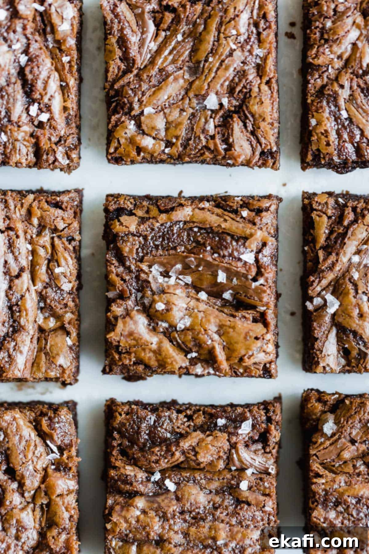 Nutella Brownies με θαλασσινό αλάτι σε νιφάδες, παραταγμένα σε λευκό φόντο.