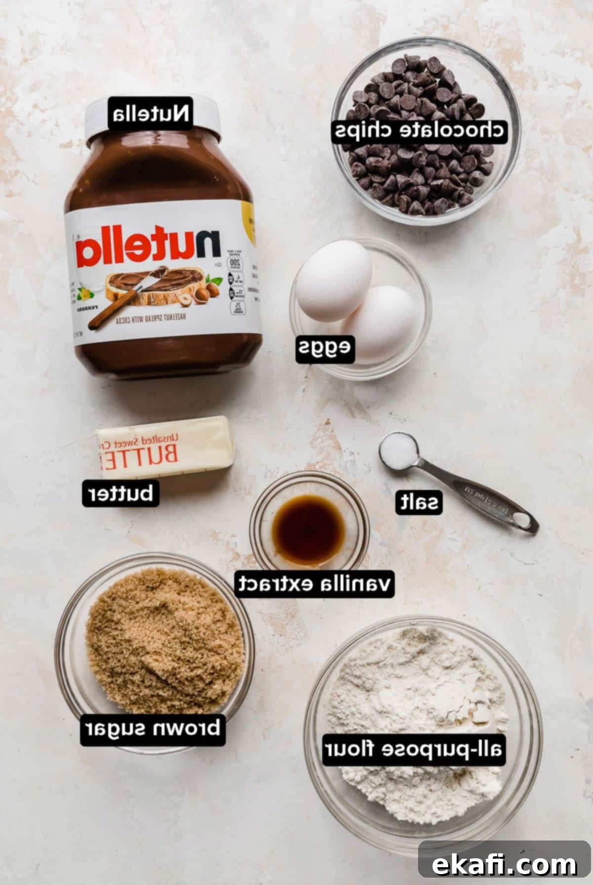 Συστατικά για Nutella Brownie απλωμένα σε λευκό ανάγλυφο φόντο.