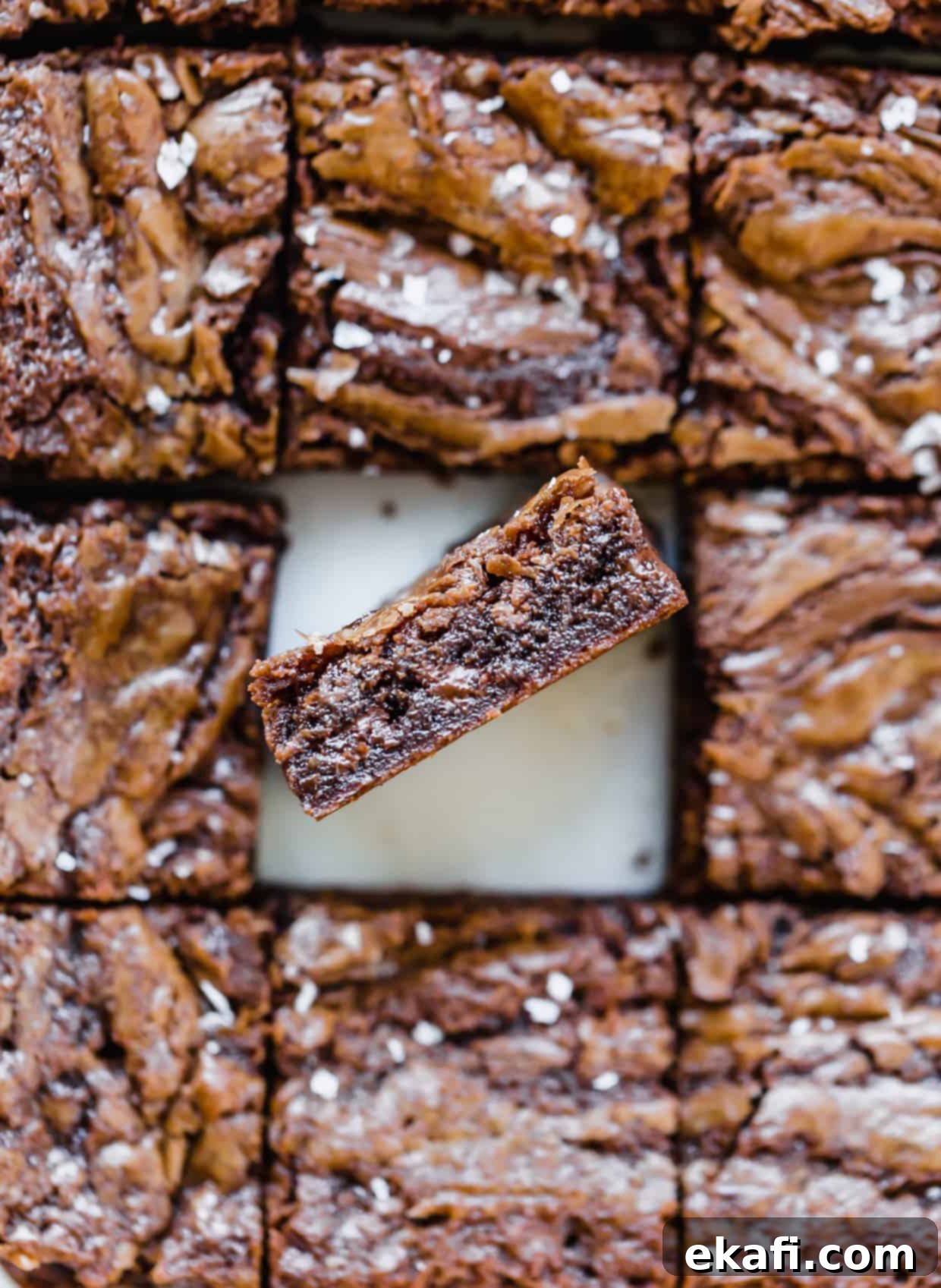 Πάνω όψη Nutella brownies κομμένα σε τετράγωνα, με ένα brownie να είναι γερμένο προς την κάμερα για να δείξει το πάχος του brownie.