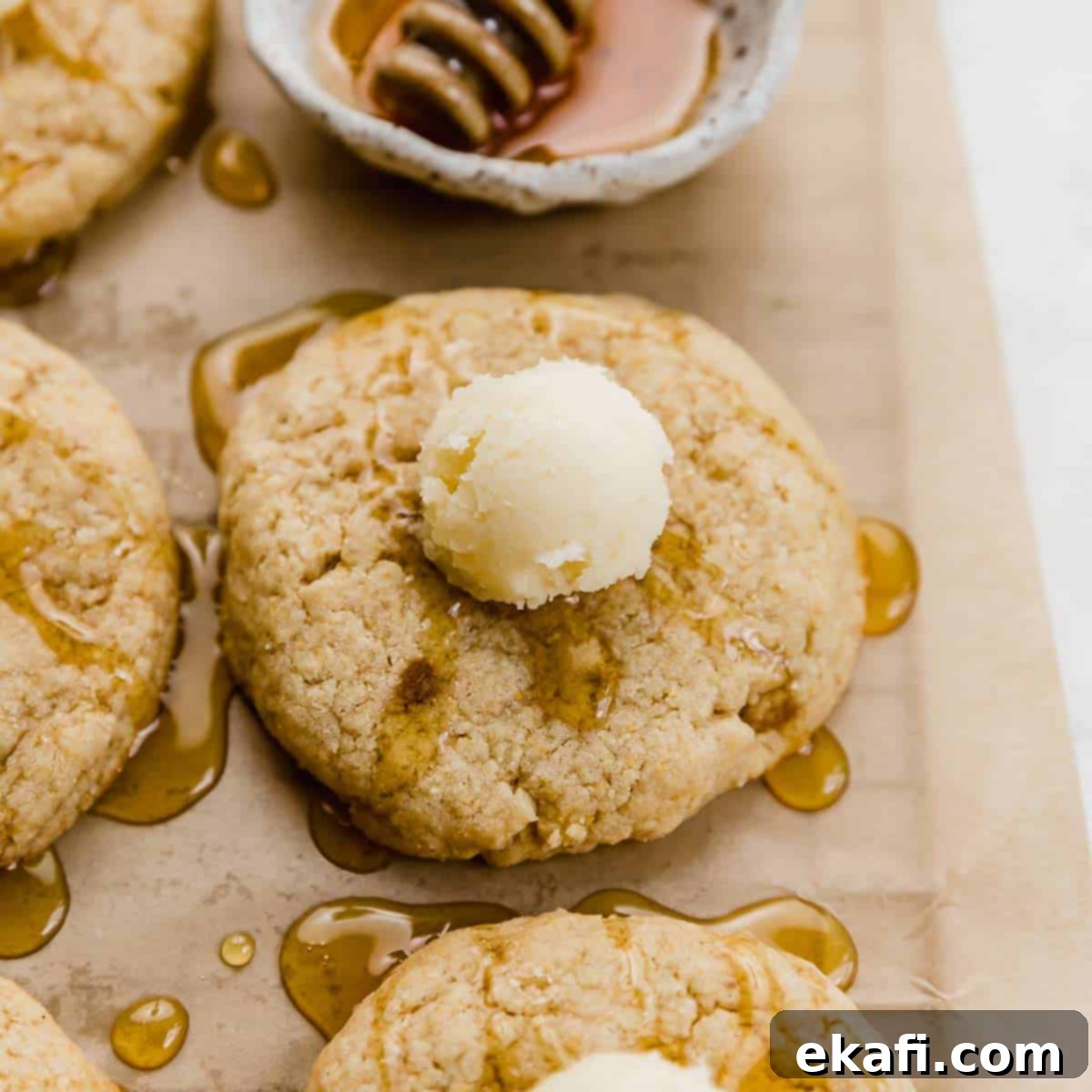 Μια μπάλα βουτύρου πάνω σε ένα Crumbl Cornbread Cookie με μέλι.