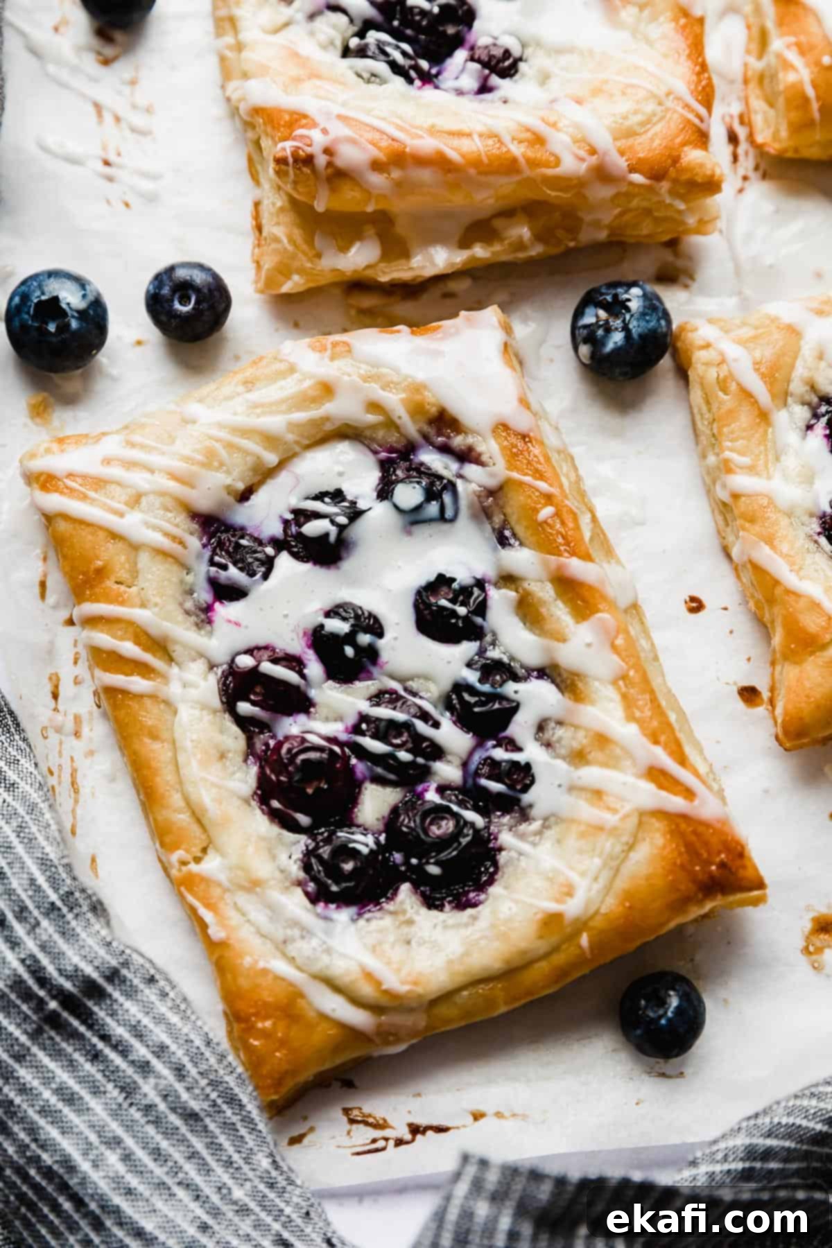 Δανέζικο Μύρτιλο 2 Ένα ορθογώνιο blueberry danish με γέμιση τυριού κρέμας, γαρνιρισμένο με γλάσο.