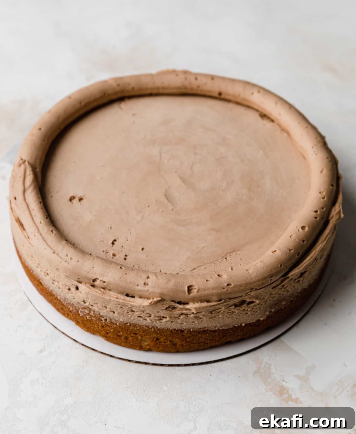 Σκοτσερού Κέικ 7 Ένα στεφάνι από γλάσο butterscotch σοκολάτας έχει διακοσμηθεί γύρω από τις άκρες μιας στρογγυλής στρώσης κέικ.