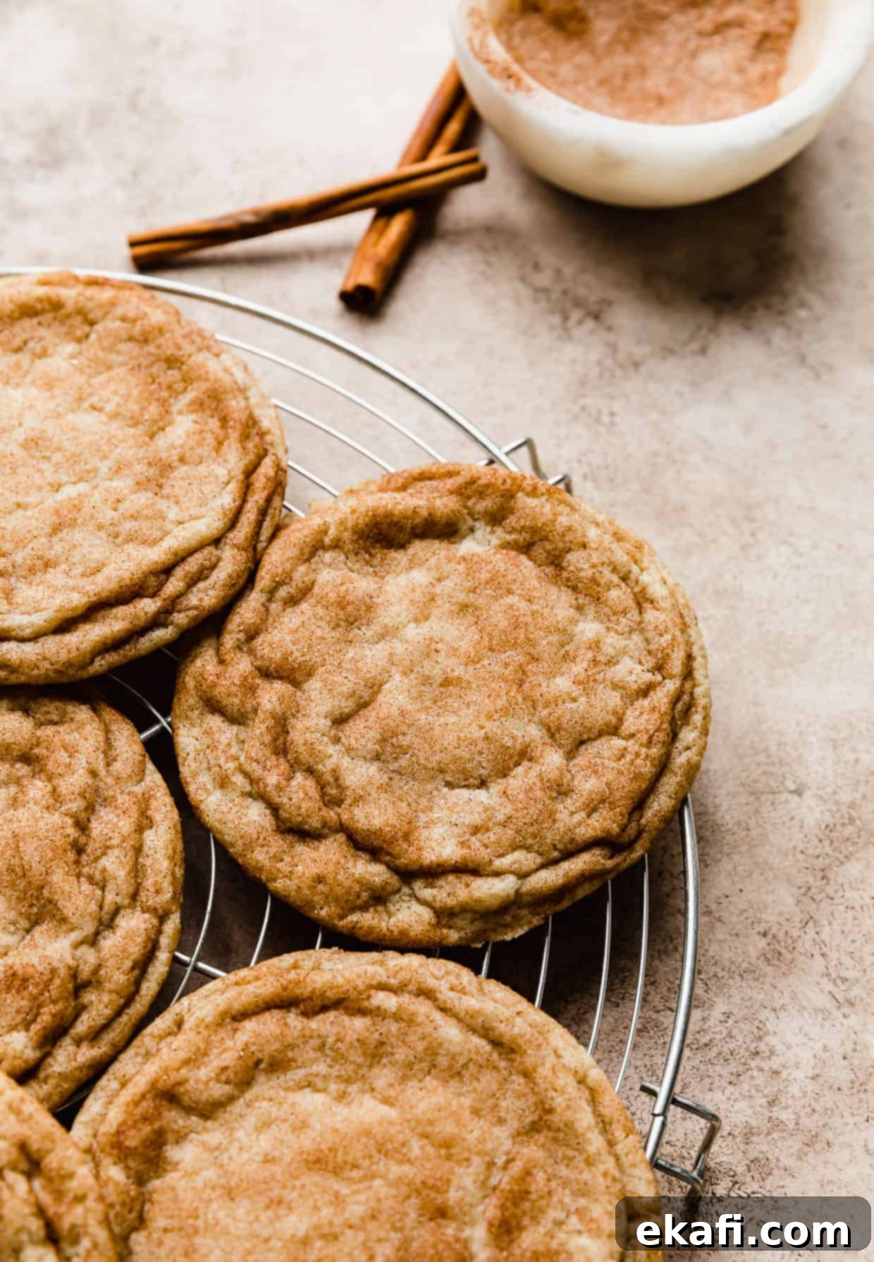 Συνταγή Κραμπλ Σνίκερντουντλ 2 Ένα μεγάλο Crumbl Snickerdoodle cookie σε στρογγυλή σχάρα ψύξης.