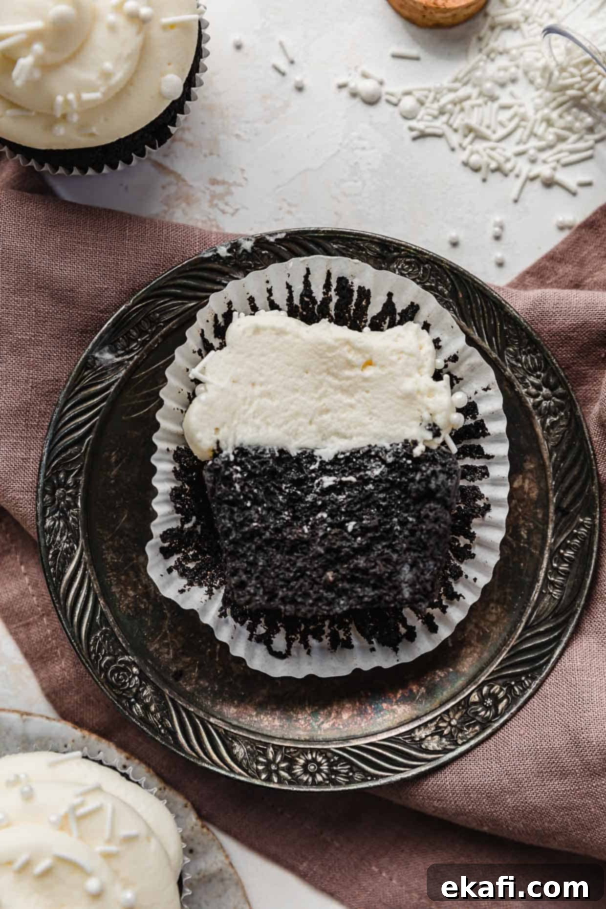 Επικάλυψη Σαντιγί 6 Ένα cupcake με μαύρο κακάο γαρνιρισμένο με σπιτικό γλάσο σαντιγί κομμένο στη μέση, σε ένα vintage πιάτο.