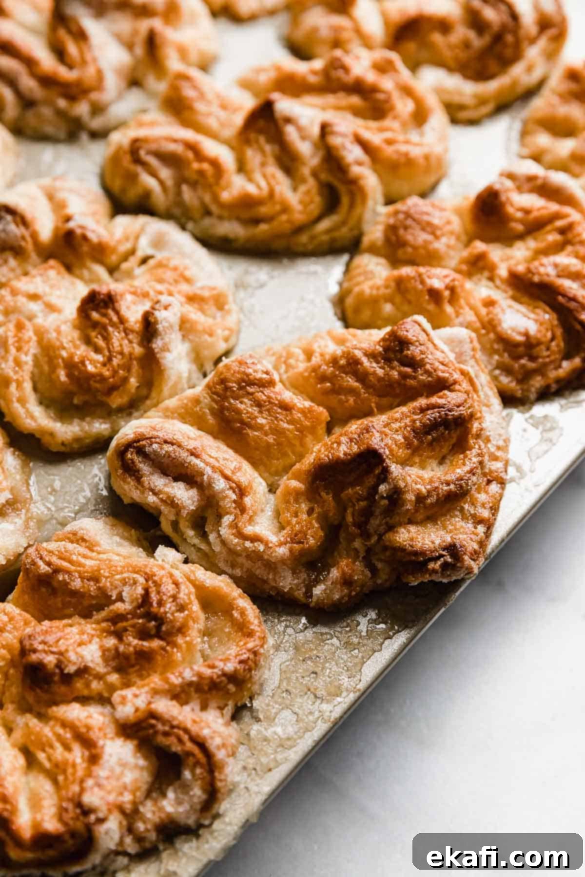Κουίν-Αμάν 11 Ψημένο σπιτικό Kouign-Amann σε φόρμα μάφιν ανοιχτού χρυσού χρώματος.