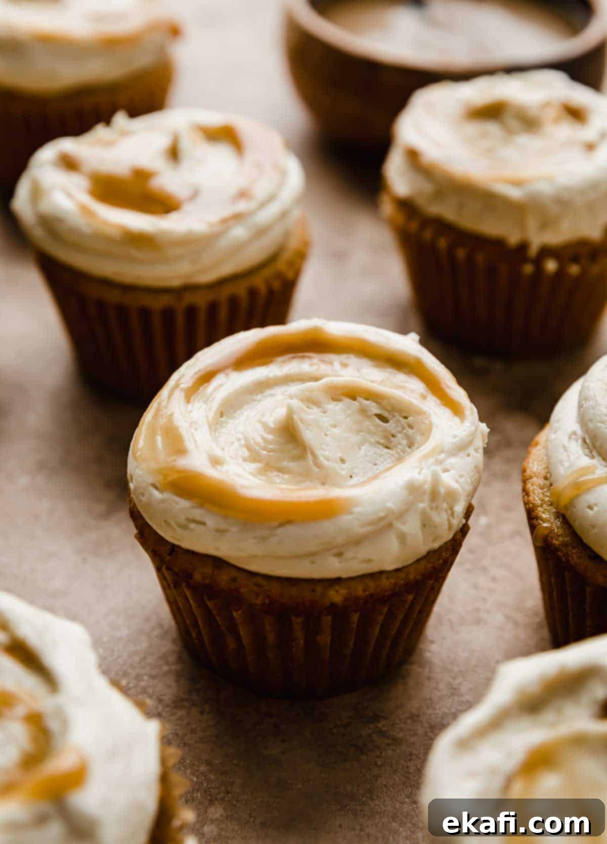 Καπκέικ Καραμέλας Βουτύρου 2 Ένα cupcake butterscotch με γλάσο καβουρδισμένου βουτύρου σε ανοιχτό καφέ φόντο.